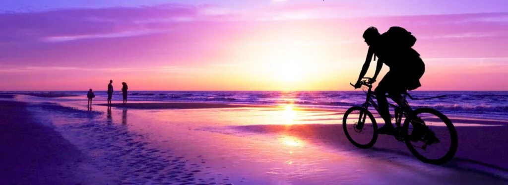 Ragazzo che corre in bicicletta al tramonto